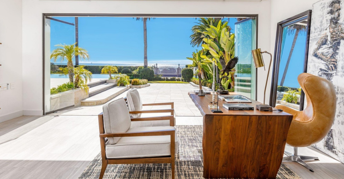 Office with frameless glass doors open to the patio