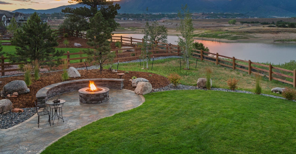 Landscaped backyard with a firepit