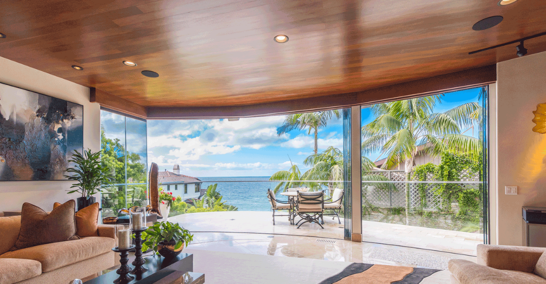 House with beautiful views of the ocean seen through a fully open frameless glass door system