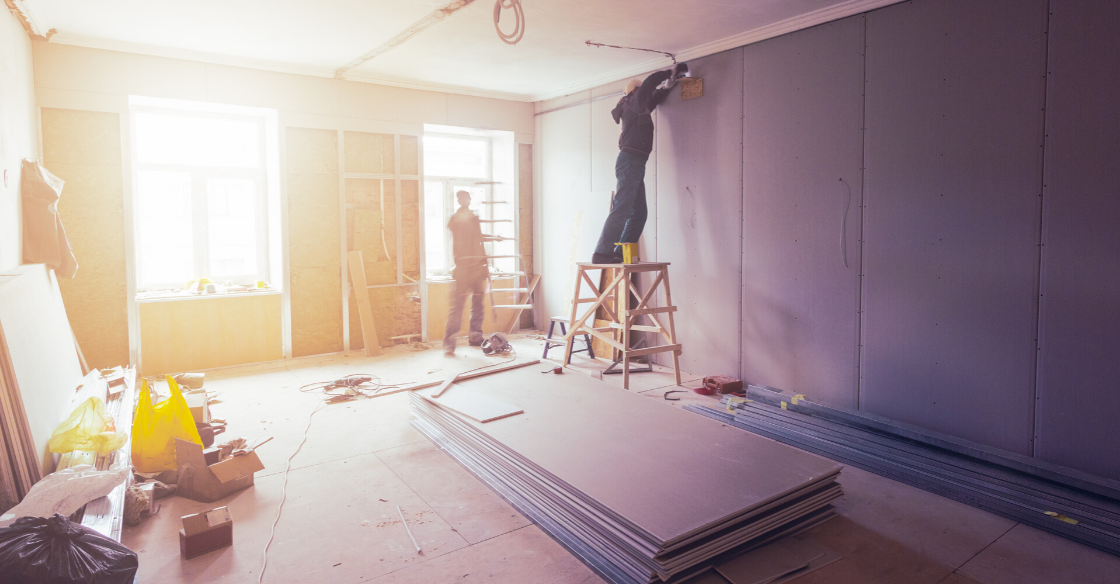 Builders installing drywall